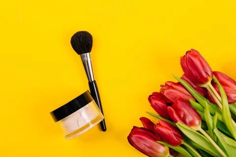 Tools for applying light refreshing makeup lie on a yellow background with .. Stock Photos