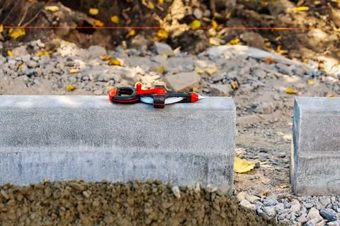 Tools are placed on concrete blocks at a construction site. Workers are pre.. Stock Photos