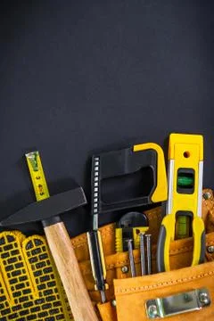 Tools in the bag for carpentry and accessories on a black background. Stock Photos