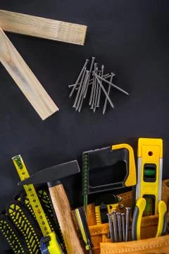 Tools in the bag for carpentry and accessories on a black background. Stock Photos
