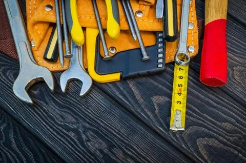 Tools in the bag for carpentry and accessories on a wooden black vintage back Stock Photos