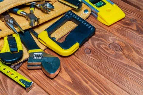 Tools in the bag for master builder prepared before work on a brown wooden bo Stock Photos
