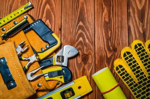 Tools in the bag for master builder prepared before work on a brown wooden bo Stock Photos