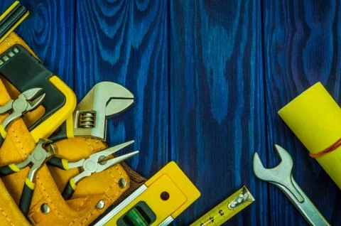 Tools in the bag for master builder prepared before work on a blue wooden boards Stock Photos