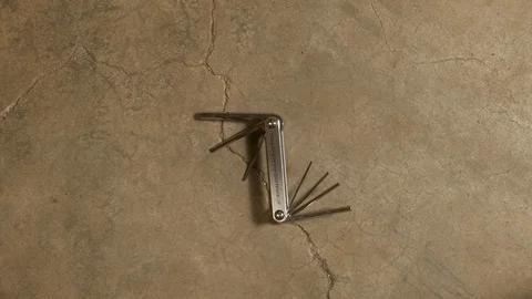 Tools being placed in frame on concrete Stock Footage 121010448