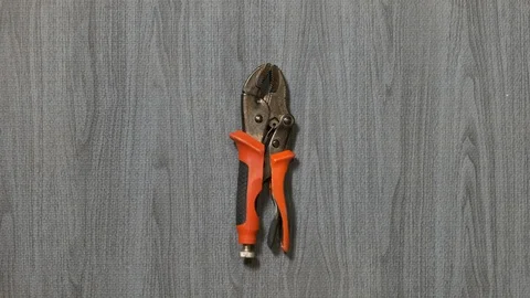 Tools being placed in frame by hand with grey wood texture backdrop Stock Footage 121005430