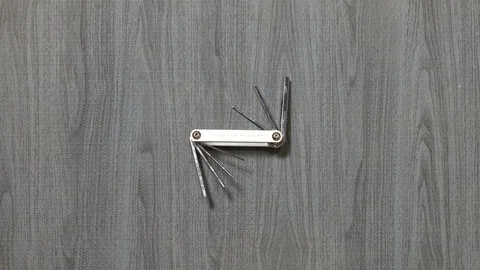 Tools being placed in frame by hand with grey wood texture backdrop Stock Footage 121005539