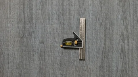Tools being placed in frame by hand with grey wood texture backdrop Stock Footage 121005549