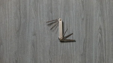 Tools being placed in frame by hand with grey wood texture backdrop Stock Footage 121005954