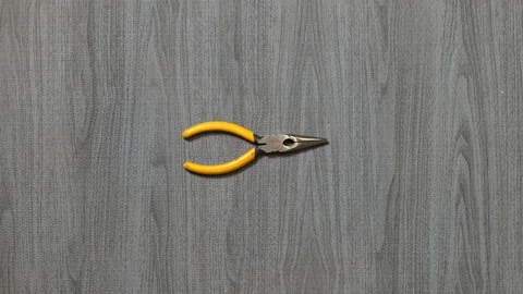 Tools being placed in frame by hand with grey wood texture backdrop Stock Footage 121006335