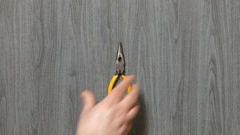 Tools being placed in frame by hand with grey wood texture backdrop Stock Footage 121006640