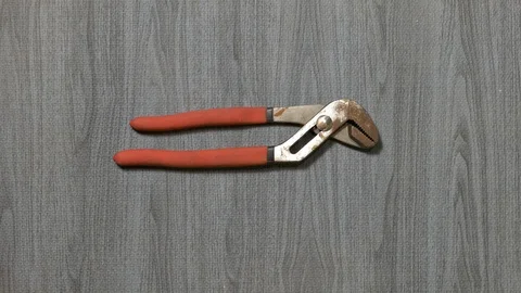 Tools being placed in frame by hand with grey wood texture backdrop Stock Footage 121007060