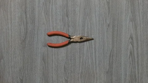 Tools being placed in frame by hand with grey wood texture backdrop Stock Footage 121007061