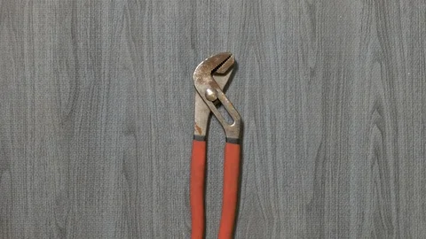 Tools being placed in frame by hand with grey wood texture backdrop Stock Footage 121007140