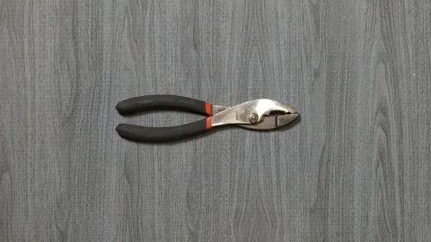 Tools being placed in frame by hand with grey wood texture backdrop Stock Footage 121007360