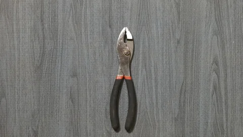 Tools being placed in frame by hand with grey wood texture backdrop Stock Footage 121007572