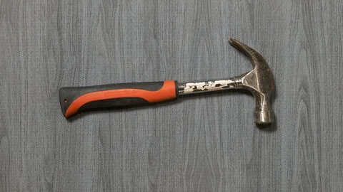 Tools being placed in frame by hand with grey wood texture backdrop Stock Footage 121008009