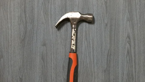 Tools being placed in frame by hand with grey wood texture backdrop Stock Footage 121008066