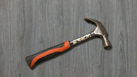 Tools being placed in frame by hand with grey wood texture backdrop Stock Footage 121008101