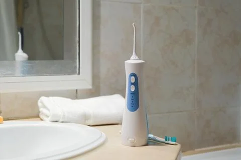 Tools for cleaning teeth in the bathroom. Portable mouth irrigator and dent.. Stock Photos