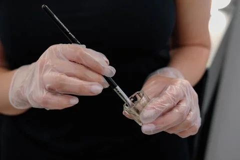 Tools for coloring and correction of eyebrows. Makeup artist stirs paint in a Stock Photos