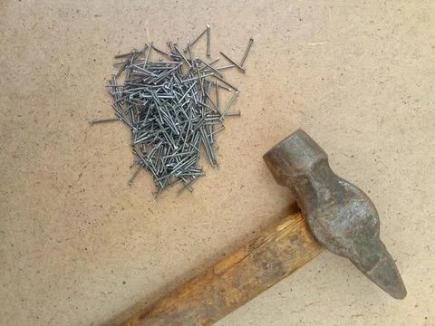 Tools for construction - hammer and small nails on a wooden background Stock Photos
