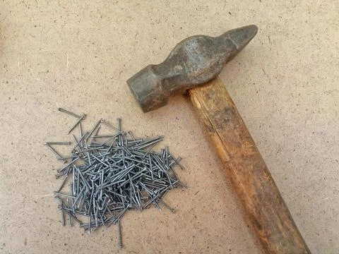 Tools for construction - hammer and small nails on a wooden background Stock Photos