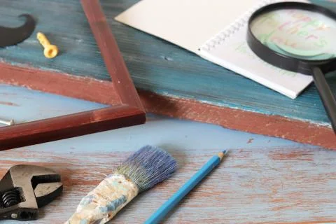 Tools, frame, notebook, congratulation on a wooden table, top view, father's day Stock Photos