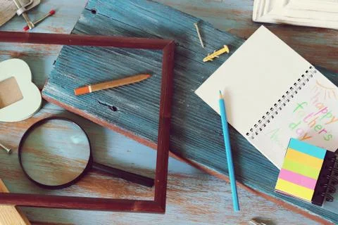 Tools, frame, notebook, congratulation on a wooden table, top view, father's day Stock Photos
