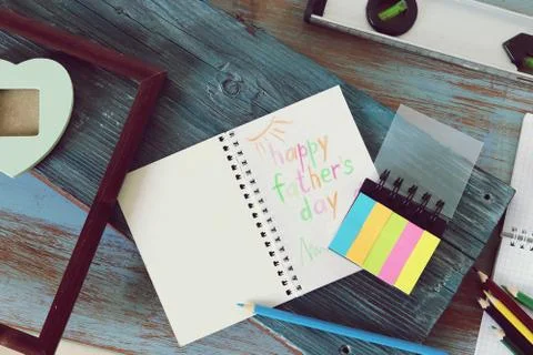 Tools, frame, notebook, congratulation on a wooden table, top view, father's day Stock Photos