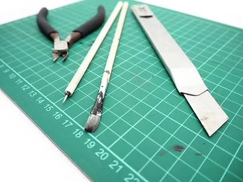 Tools with green cutting mat for model kit isolated on white background. Stock Photos