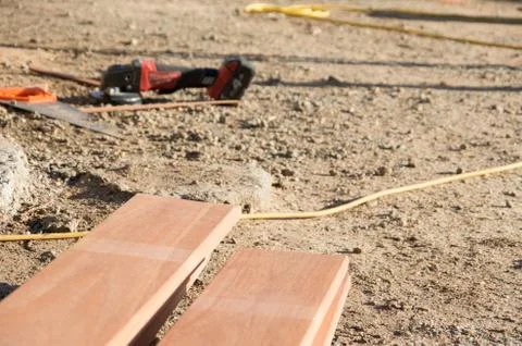 Tools on the ground in front of a stack of planks Stock Photos