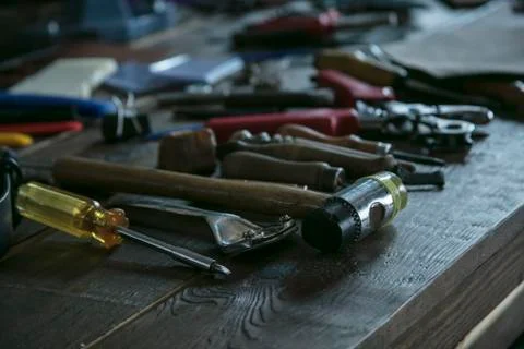 Tools for leather working on wooden table. Toolkit for leather worker Stock Photos