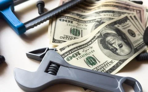 Tools lying over banknotes background Stock Photos