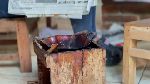 Tools for making traditional batik cloth. The "canting" tool is in a pan Stock Footage 278866382