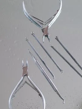 Tools for manicure on a mirror surface. Cleanliness, sterilization, top view Stock Photos
