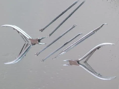 Tools for manicure on a mirror surface. Cleanliness, sterilization, top view Stock Photos