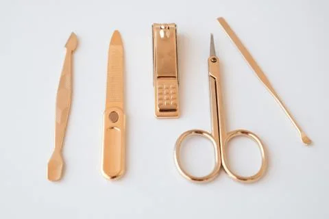 Tools of a manicure set on a white background. Gold color tools Stock Photos