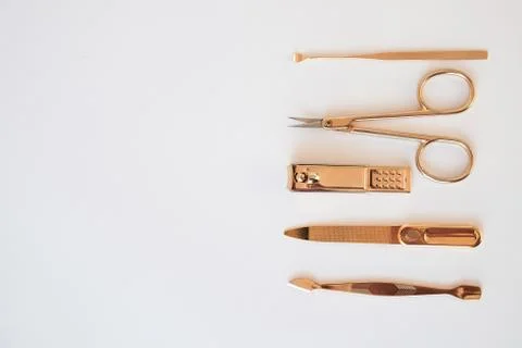 Tools of a manicure set on a white background. Gold color tools Stock Photos