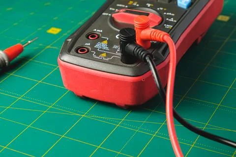 Tools measuring voltage and current on a vibrant green grid background Stock Photos