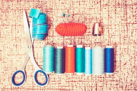 Tools for needlework, red knitted needle pad for sewing, scissors and colored Stock Photos