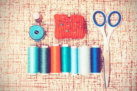 Tools for needlework, red knitted needle pad for sewing, scissors and colored Stock Photos