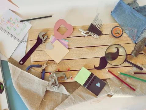Tools, paper mustache, notepad, congratulation on a wooden table, top view Stock Photos