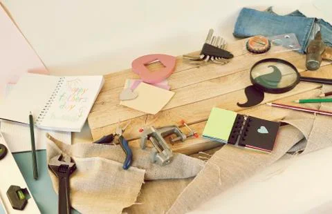 Tools, paper mustache, notepad, congratulation on a wooden table, top view Stock Photos