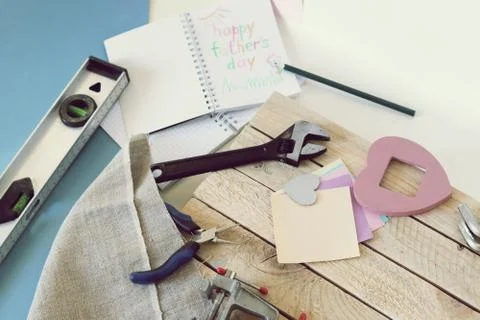 Tools, paper mustache, notepad, congratulation on a wooden table Stock Photos