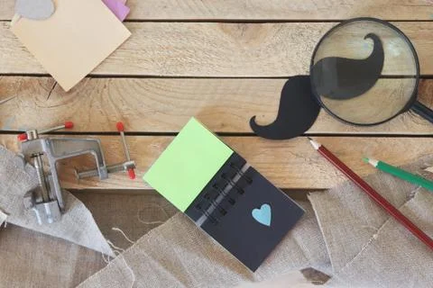 Tools, paper mustache, notepad, congratulation on a wooden table Stock Photos