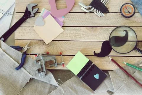 Tools, paper mustache, notepad, congratulation on a wooden table, top view Stock Photos