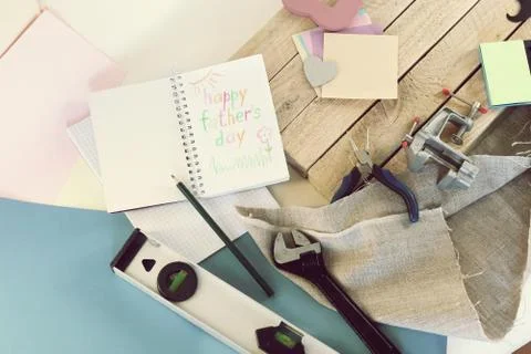 Tools, paper mustache, notepad, congratulation on a wooden table, top view Stock Photos