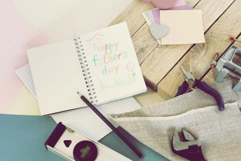 Tools, paper mustache, notepad, congratulation on a wooden table, father's day Stock Photos