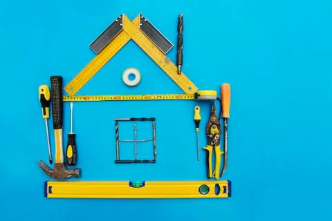 Tools in the shape of house over blue background. Home improvement concept. Stock Photos